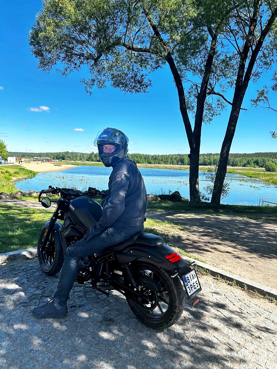Motocyklista nad wodą podczas wycieczki po Podlasiu